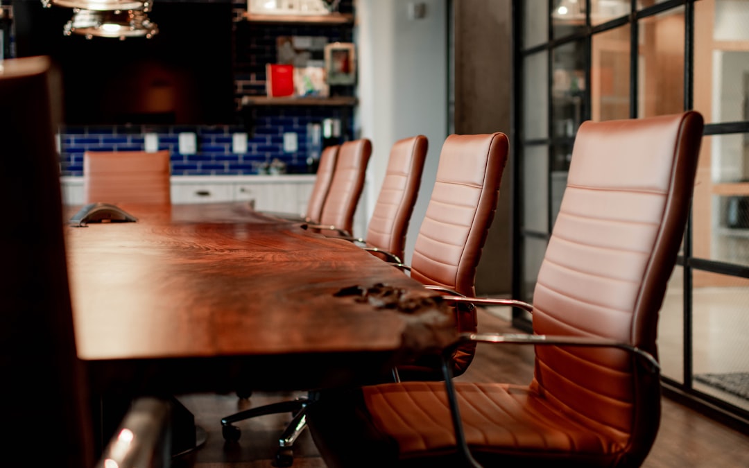 A conference room with a large wooden table and leather chairs corporate failure, leadership, boardroom