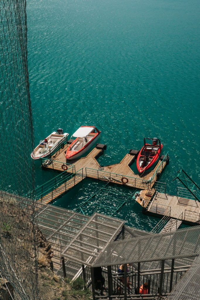 A couple of boats that are sitting in the water high performance pontoon, fast boat, lake scenery