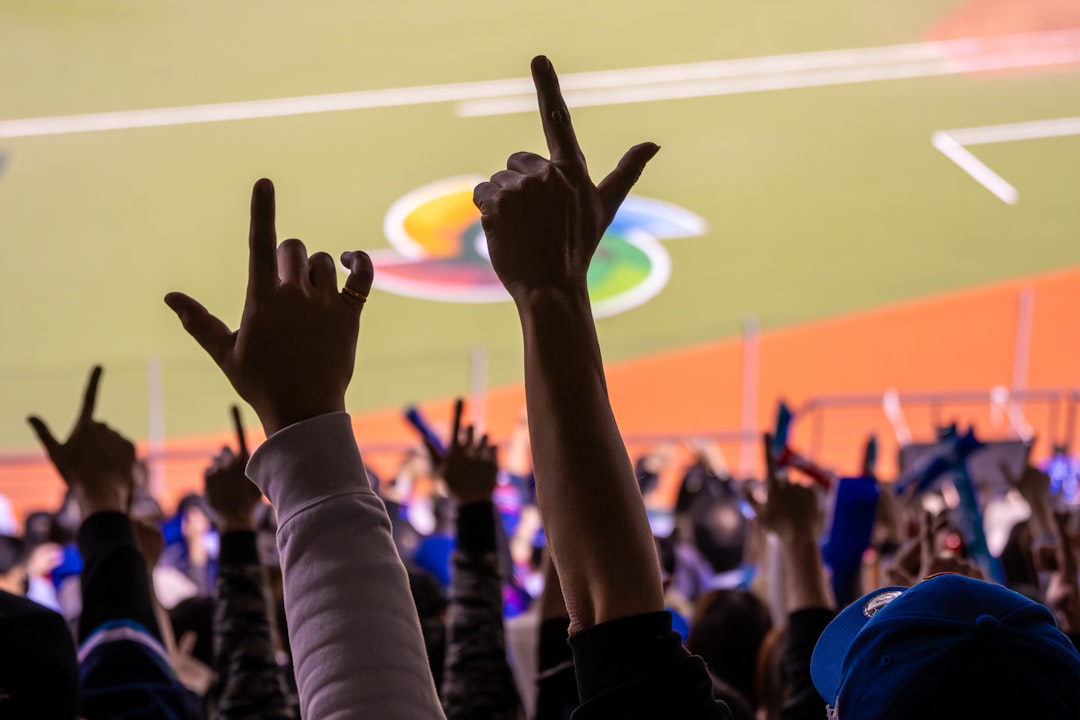A crowd of people raising their hands in the air baseball parents cheering, family support, youth sports crowd
