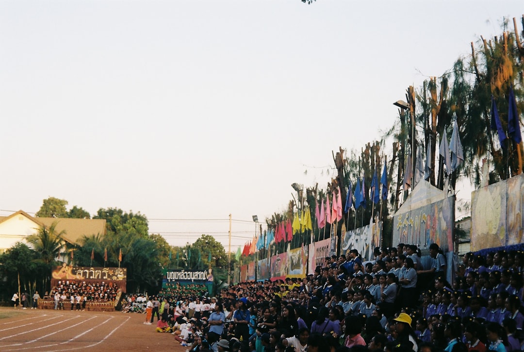a crowd of people watching a plane fly overhead international softball, olympic softball, global teams