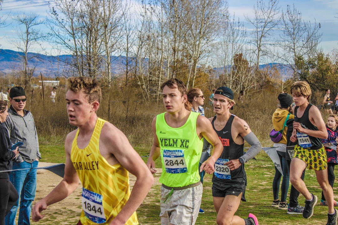 a group of people running in a race cross country team, runners trail, fall practice