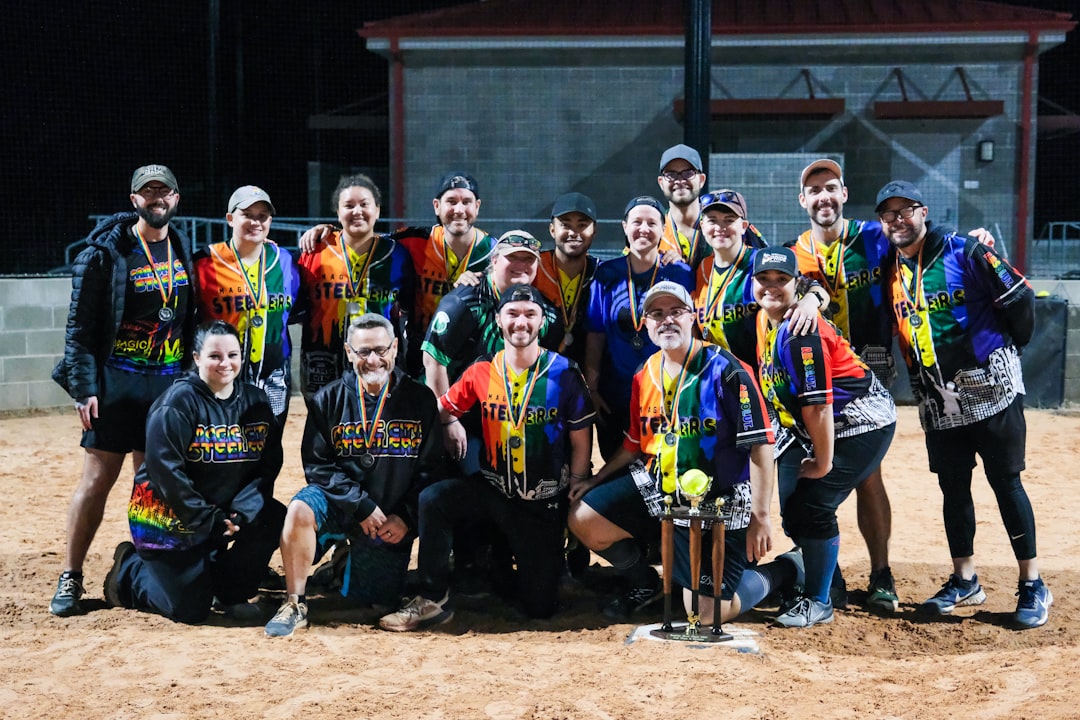 A group of people standing next to each other on a dirt field competitive paintball match stadium team