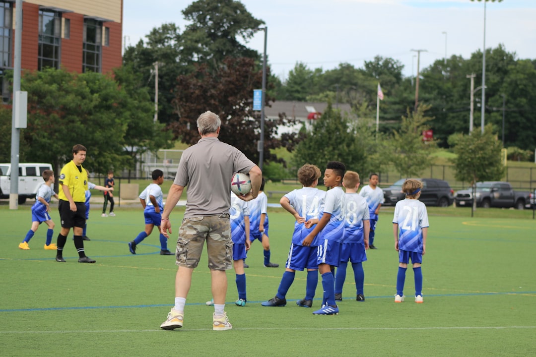 a group of young men standing on top of a soccer field football practice coach training drills blue flag