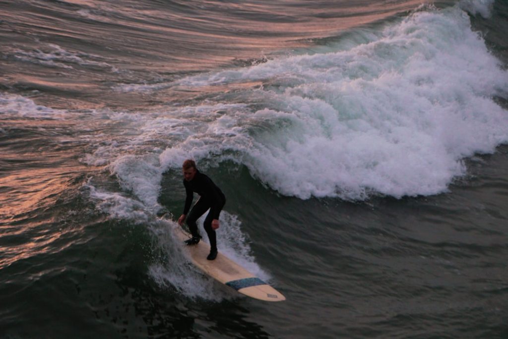 a man riding a surfboard on a wave in the ocean wakesurf surfer spin wake trick boat