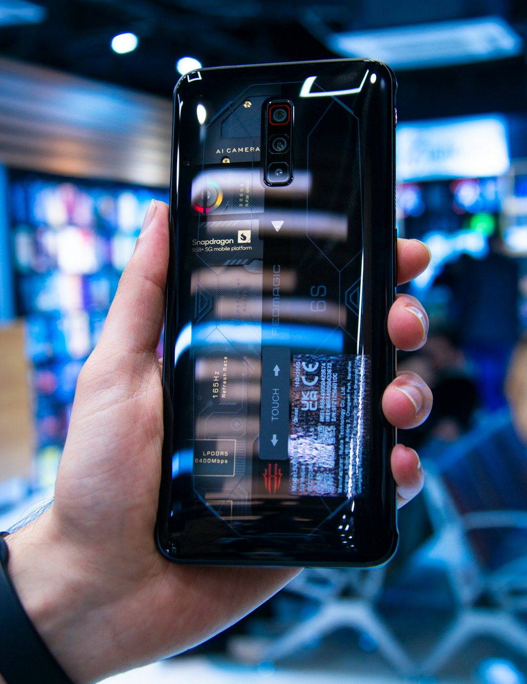 a person holding a cell phone in their hand nubia neo2 gaming controls, shoulder triggers, game mode, phone in hands