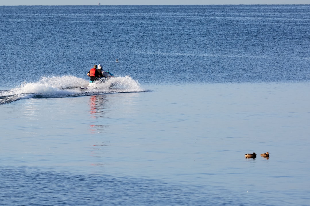 a person on a jet ski in the water water ski group safety boat communication signals
