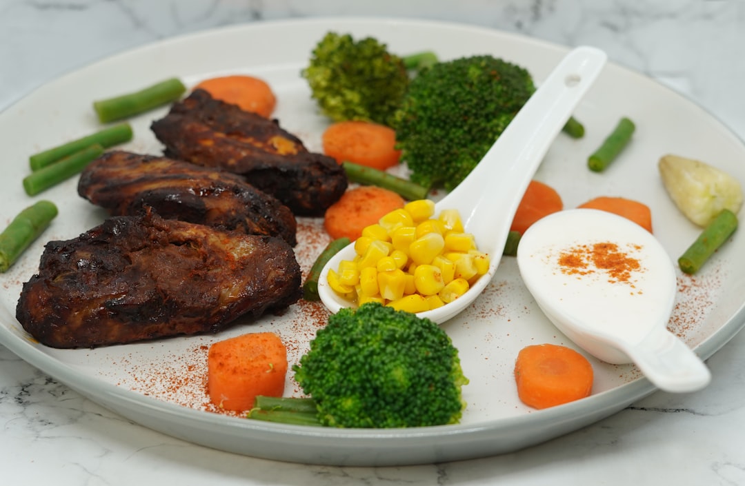 a white plate topped with meat and veggies grilled chicken, protein meal, fitness food