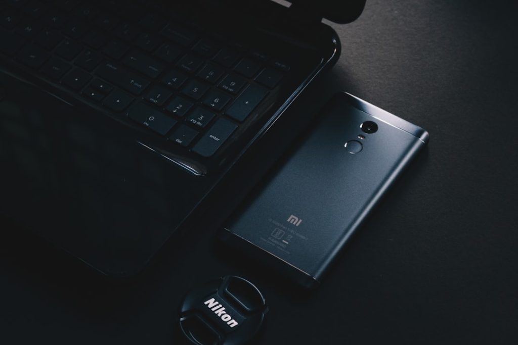 black lg android smartphone on black laptop computer xiaomi redmi 13r, budget 5g phone, front and back