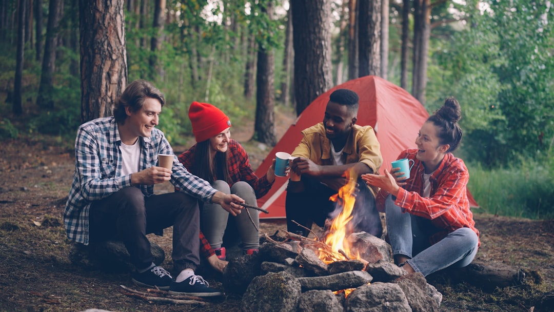 Friends gathered around a campfire in a forest. team bonding, camping trip, football players outdoors