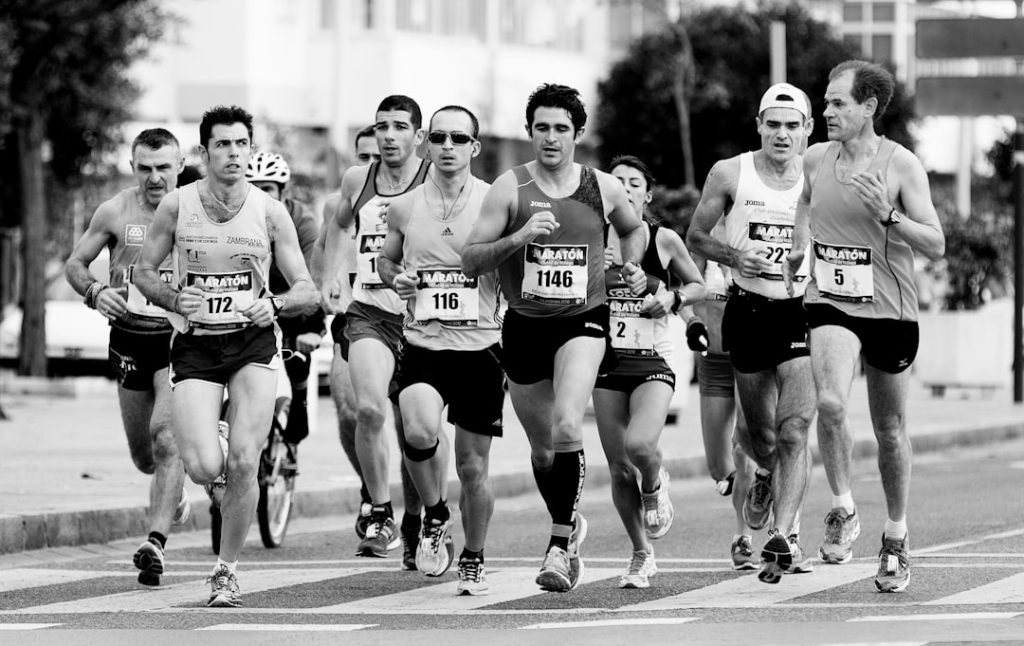 grayscale photo of people performing marathon sprint triathlon, beginner athletes, race start