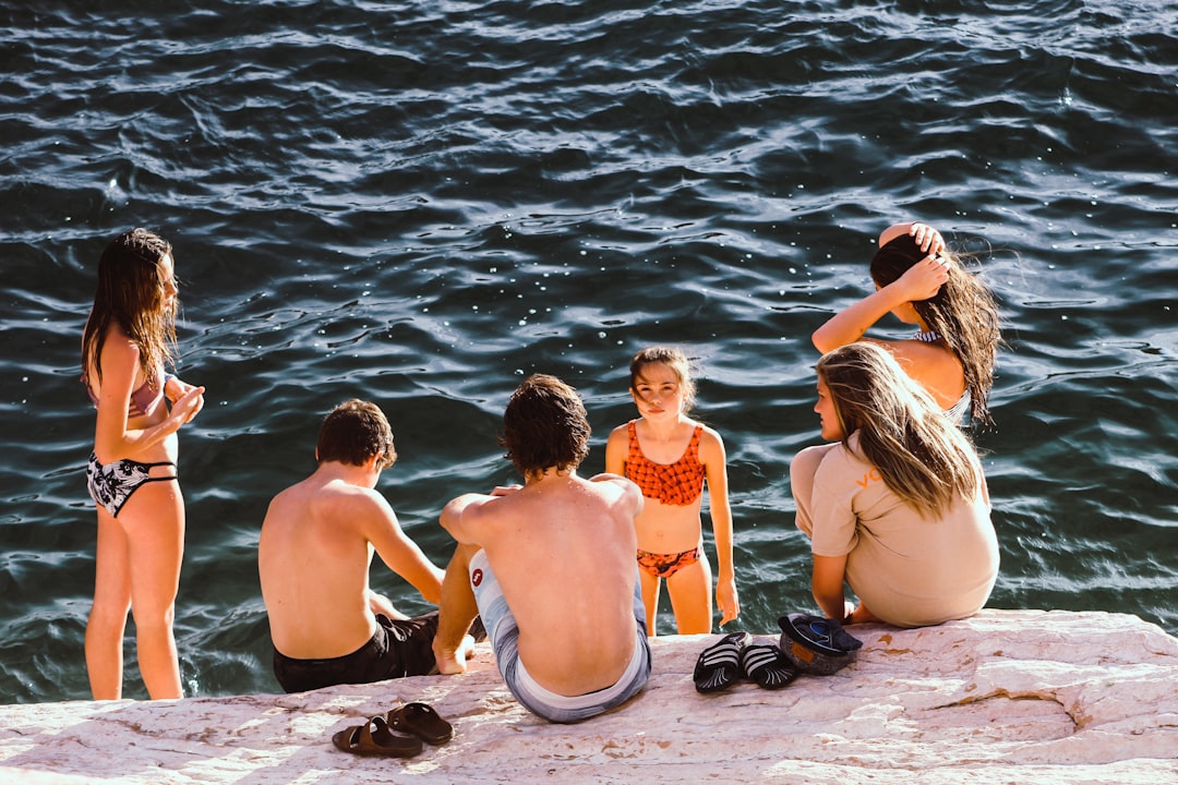 group of kids having a conversation near body of water wakeboarding group, lake, summer fun