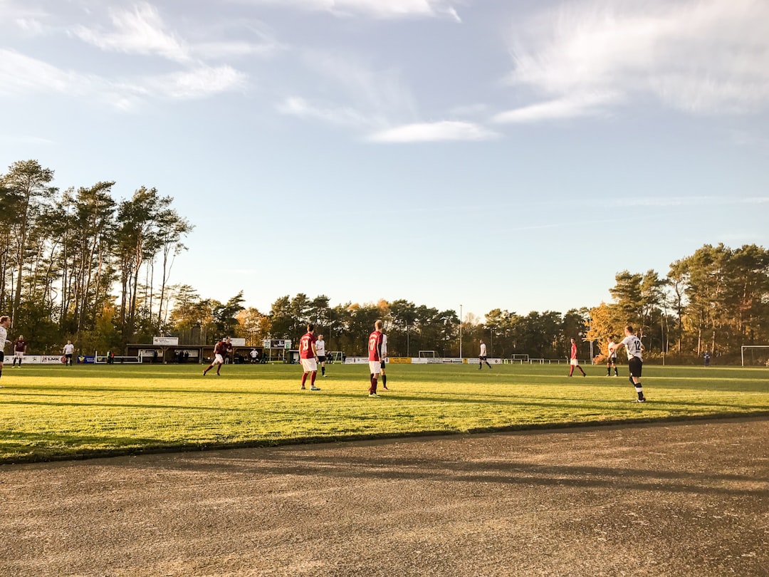 landscape photography of people playing soccer on field during daytime paintball field players action
