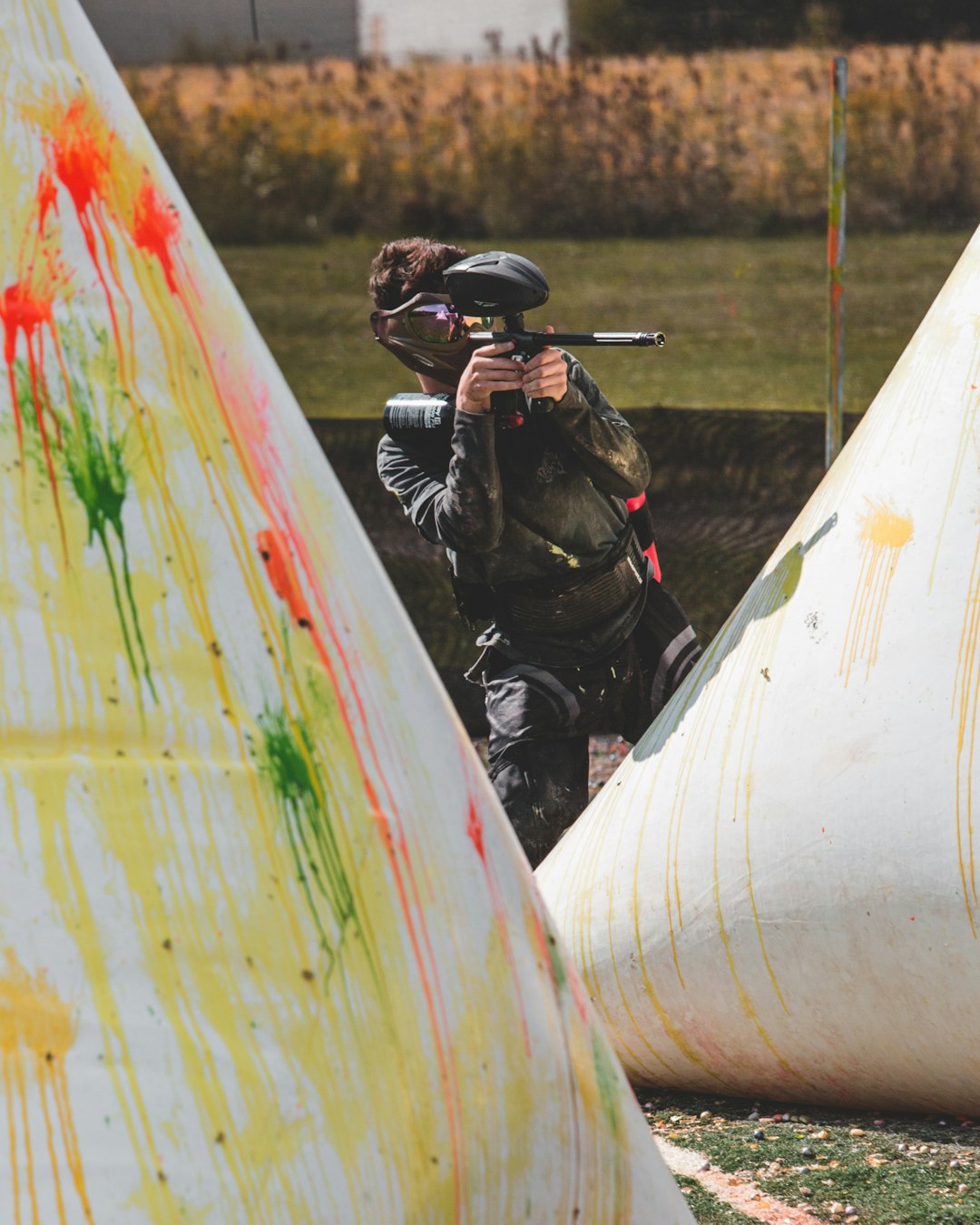 man in black helmet riding motorcycle during daytime paintball field players action