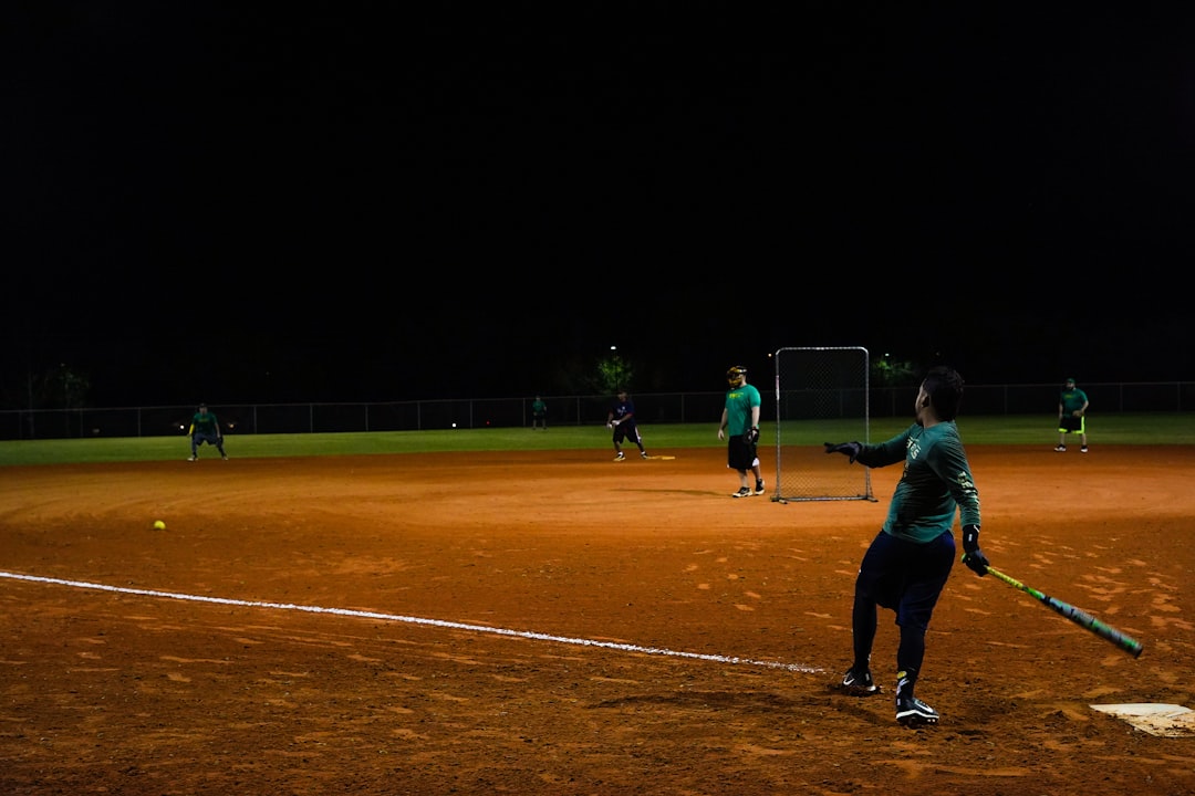 men playing baseball during nighttime competitive paintball match stadium team