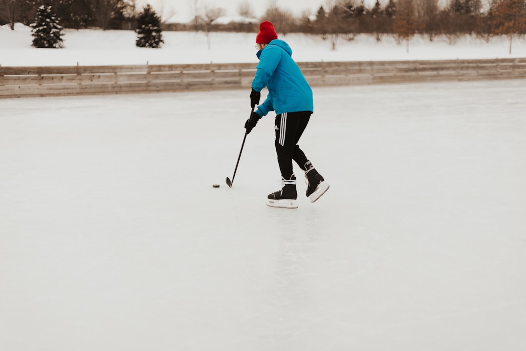 person playing hockey stick curling team, players sweeping, curling match