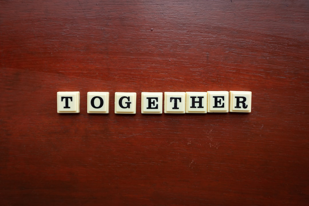 the word together spelled with scrabble tiles on a wooden surface local link building events community partnership