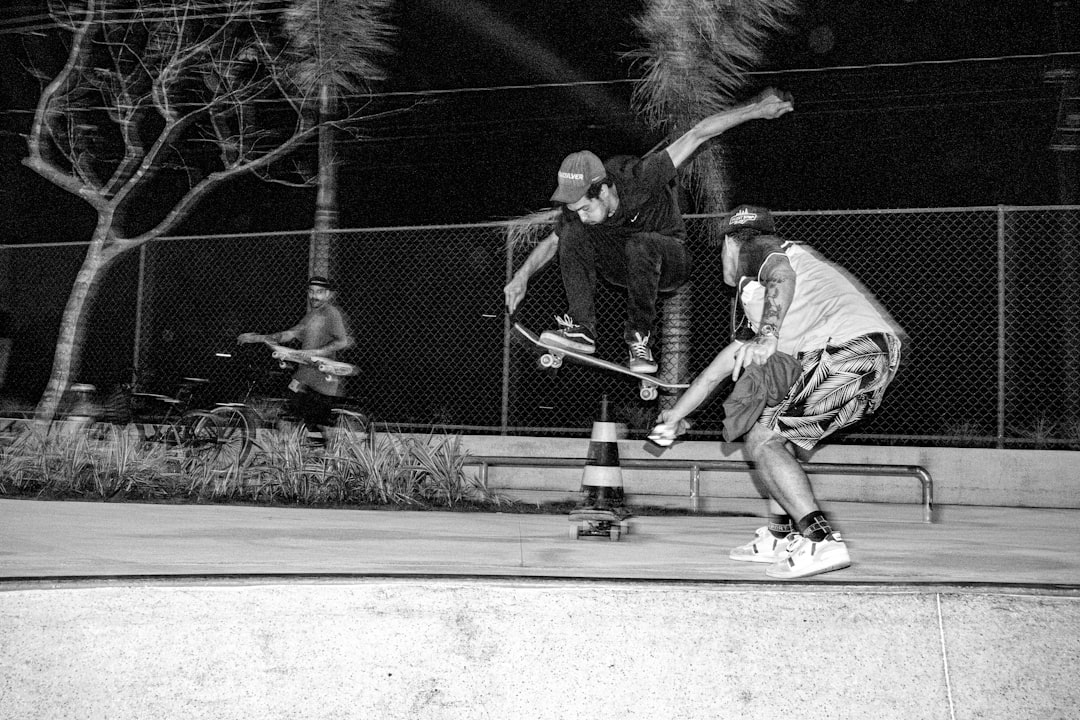 Two skateboarders performing tricks at night willis reed, knicks vs lakers, 1970 nba finals, madison square garden