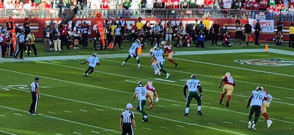 A group of people playing a game of football dolphins offense, tua pass, rams defense, nfl action