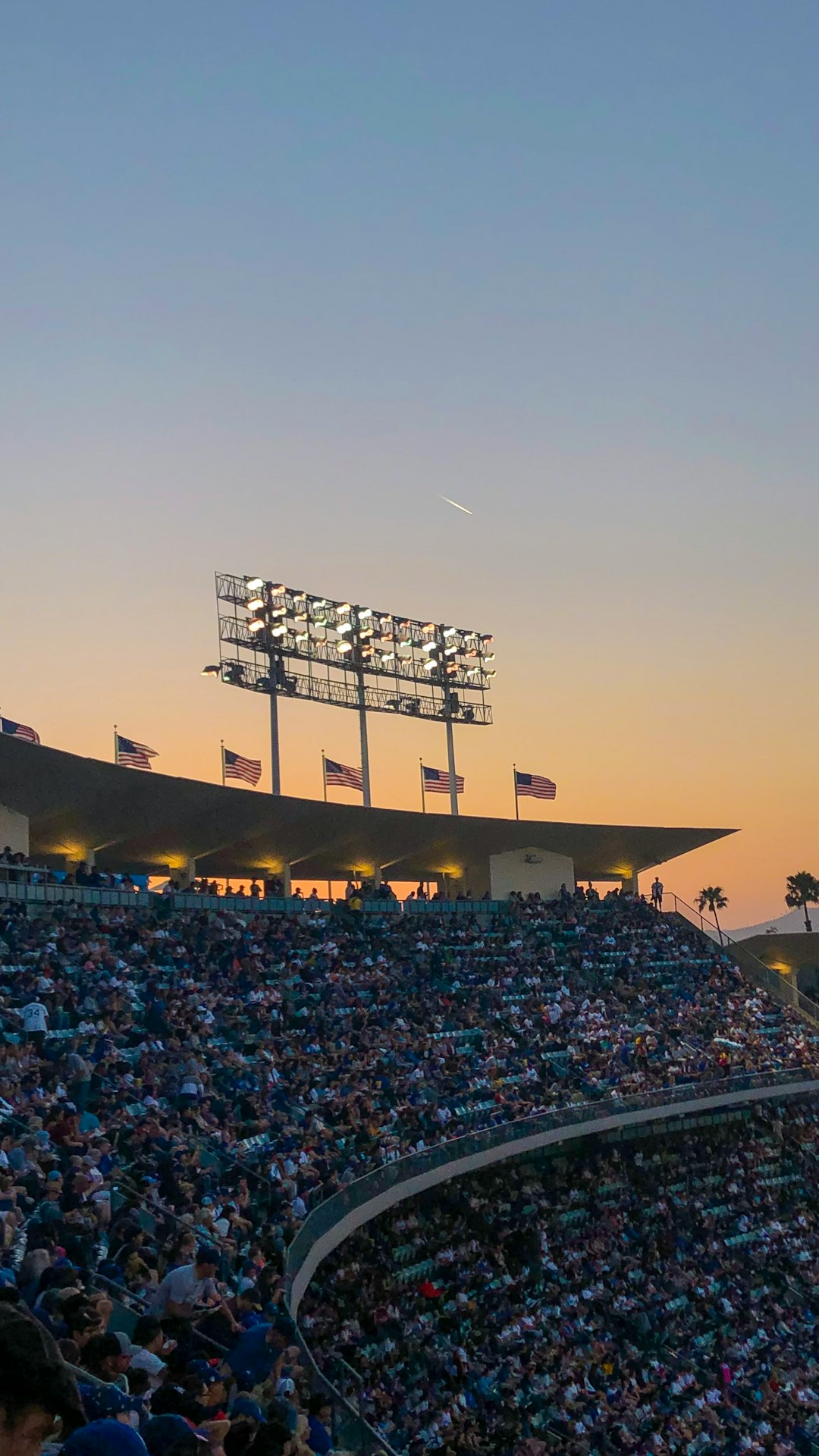 people sitting on stadium chairs during golden hour dodgers marlins game night stadium crowd