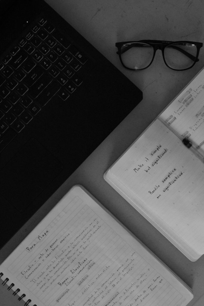 white printer paper on black laptop computer student desk, organizing pdf files, college notes