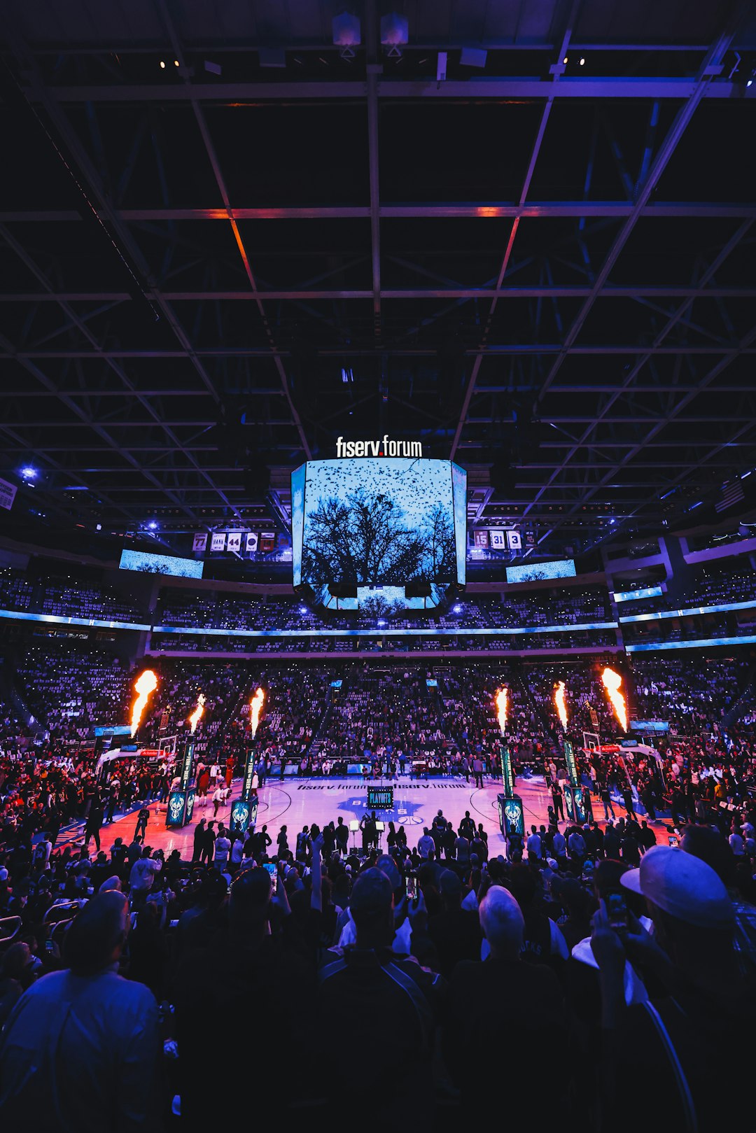 a crowd of people watching a basketball game nba point guard driving, arena lights, intense basketball moment