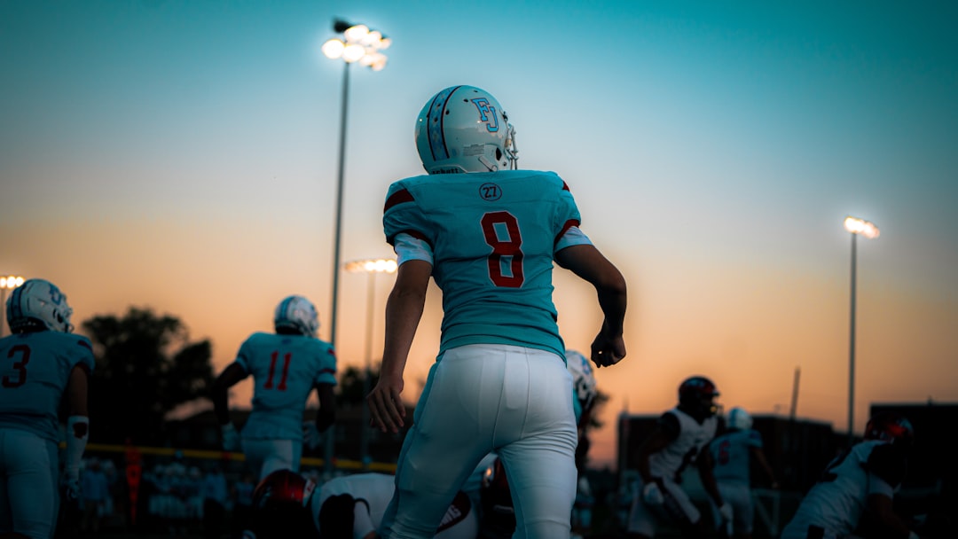 a football player in a blue uniform quarterback throwing football, nfl stadium lights, football action shot
