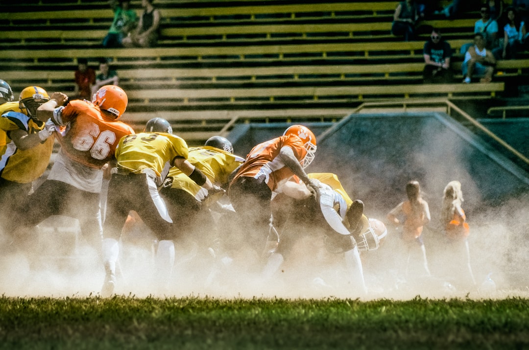 a group of football players running onto the field nfl defense sack, quarterback pressure moment, stadium lights football