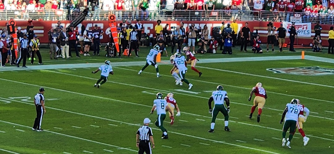 A group of people playing a game of football nfl defense sack, quarterback pressure moment, stadium lights football