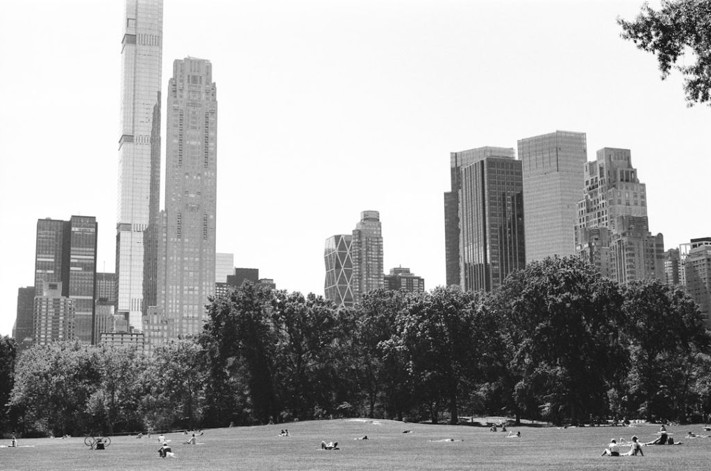 a park with tall buildings in the background vintage golf tournament, 1960s golf crowd, old golf trophy