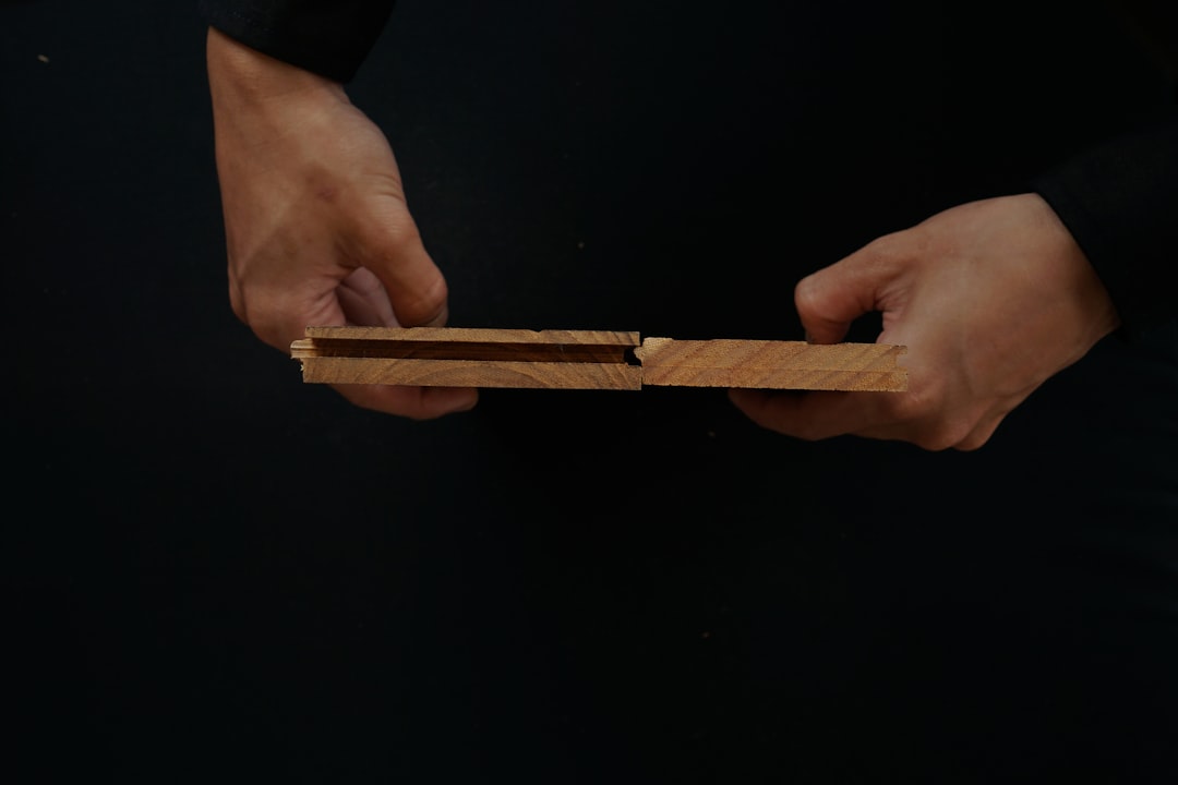 a person holding a piece of wood in their hands player sliding shuffleboard puck, cue stick action, shuffleboard technique, close up shuffleboard disc