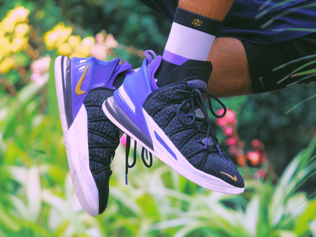 a person's feet in a shoe on grass lebron james basketball, nba game action, lakers uniform