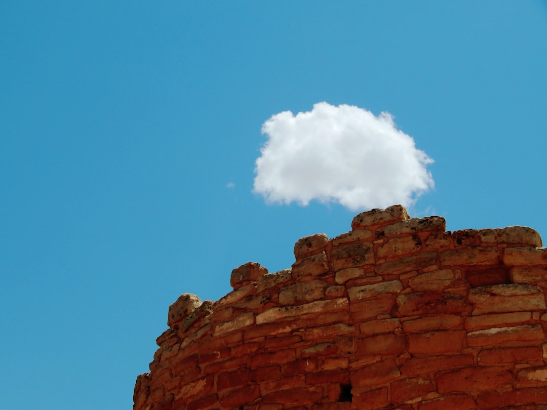 A single cloud floats above ancient stone ruins. cloud hosting, ecommerce performance, future technology