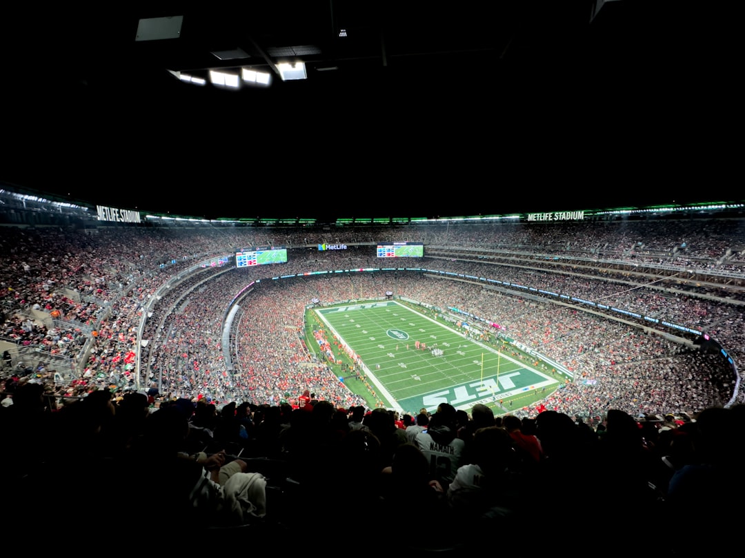 a stadium filled with lots of people watching a football game wide receiver catch, nfl sideline celebration, packed stadium crowd