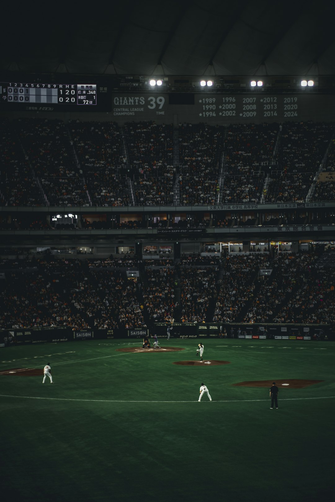 Baseball players on the field during a night game scoreboard baseball stadium, fans cheering crowd, night game atmosphere