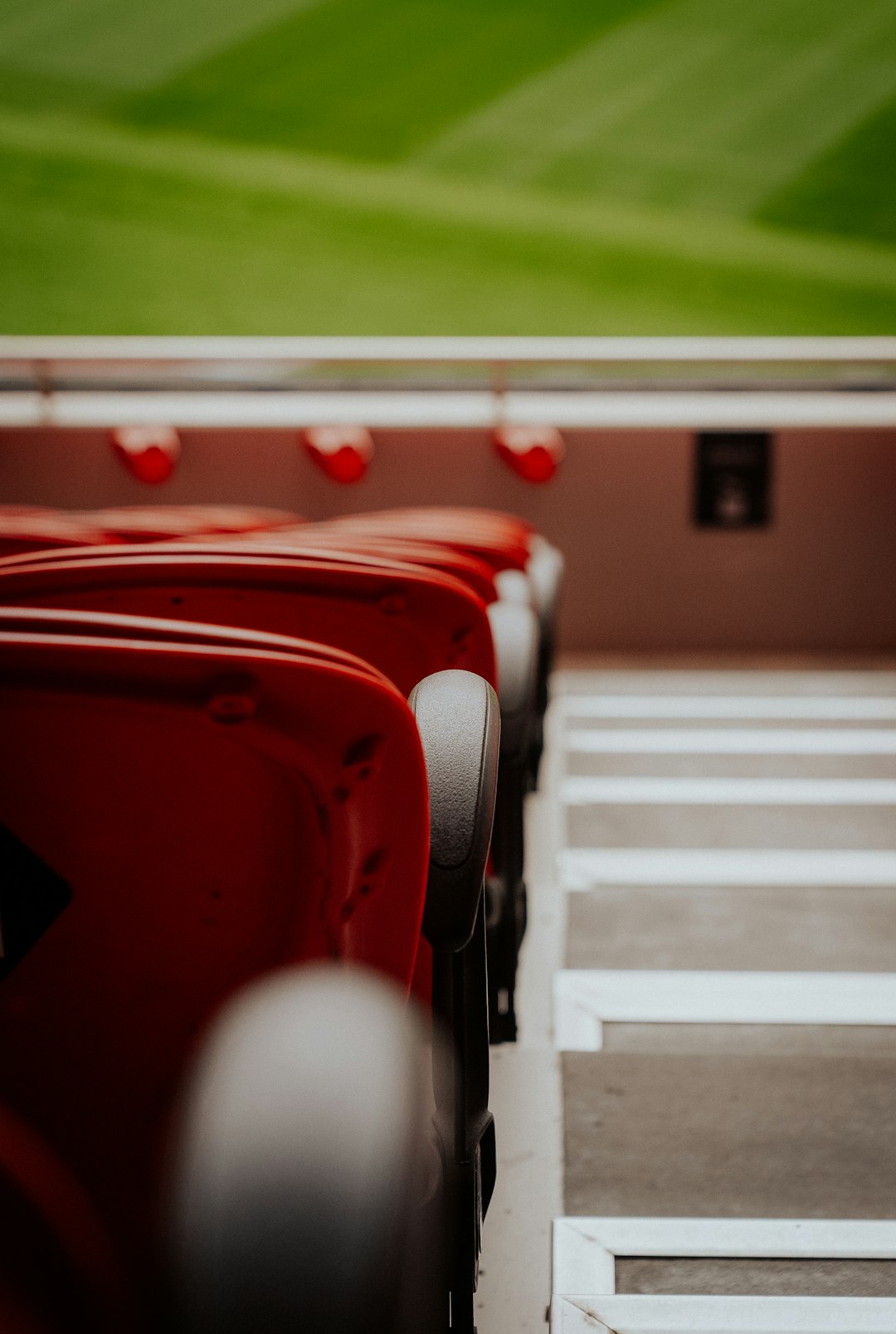 Empty red stadium seats with green field above Manchester United lineup formation, football pitch graphic, red team formation