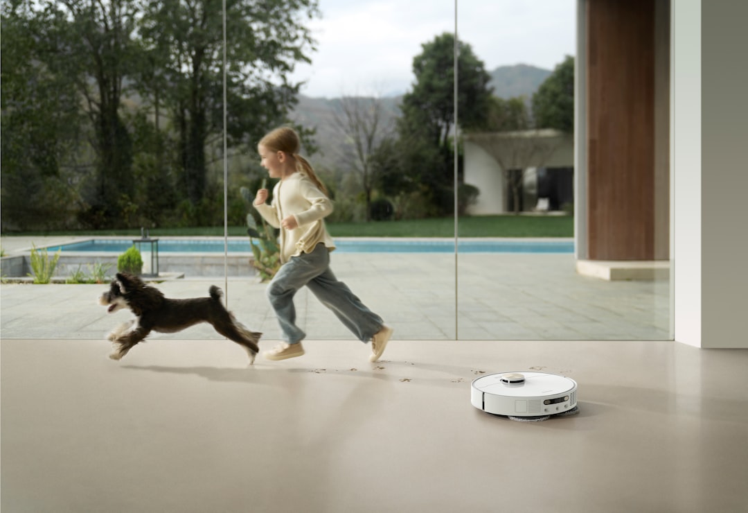 Girl and dog run past robot vacuum cleaner smart home devices, automation, budget technology