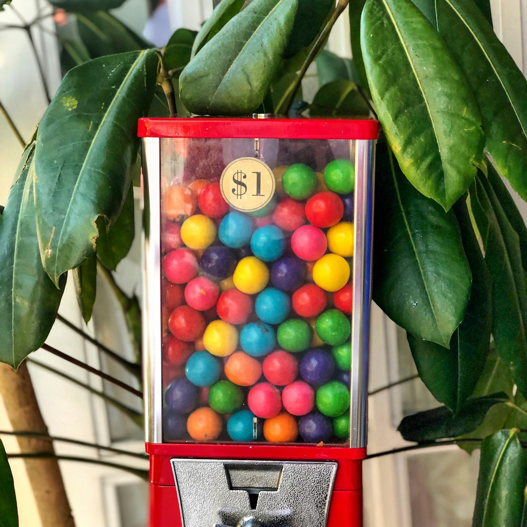 gumball dispenser beside plant lottery balls machine, numbered balls, drawing in progress