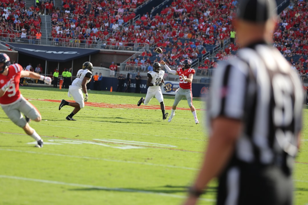 men's white and red jersey shirt quarterback throwing football, nfl stadium lights, football action shot