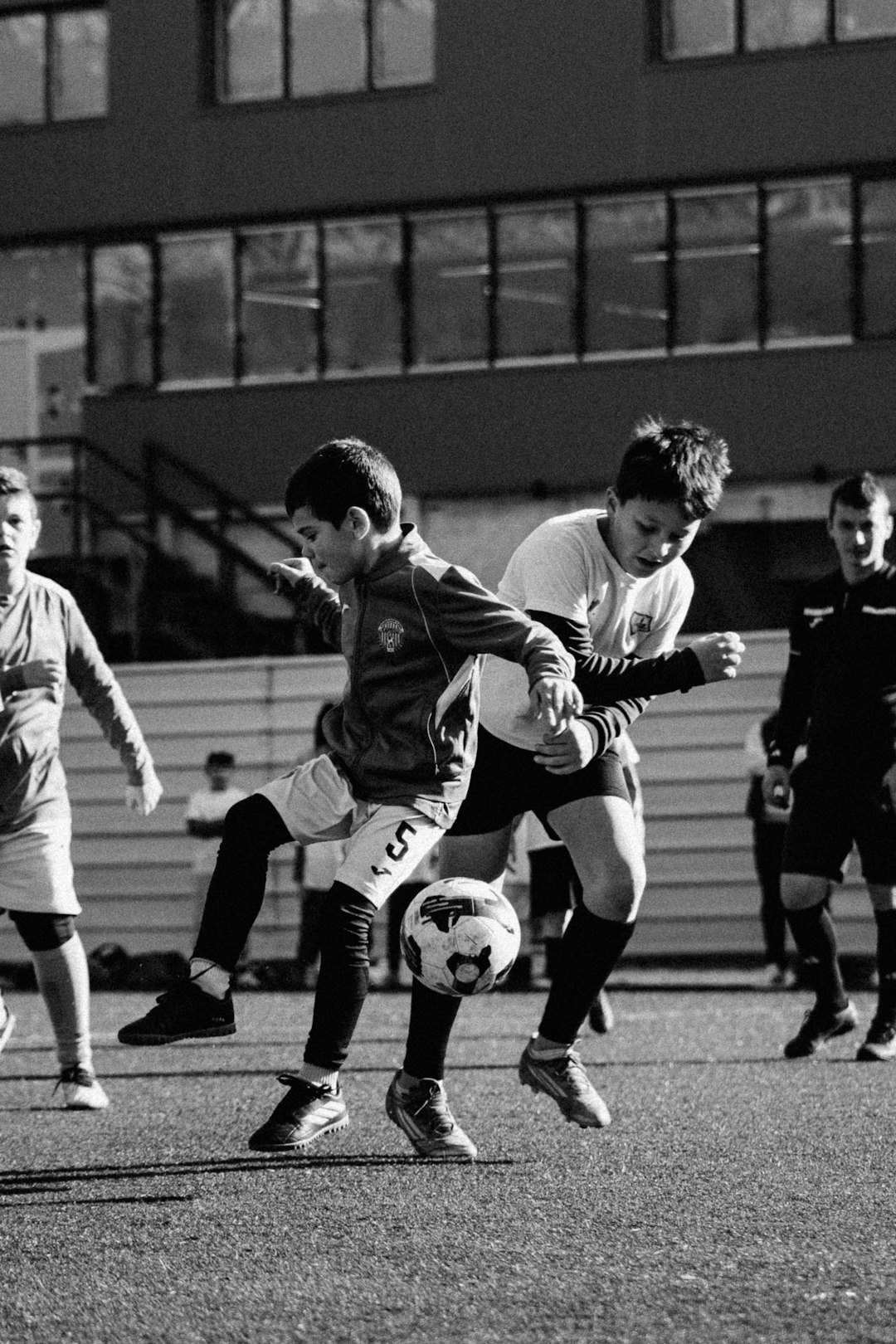 Two boys playing soccer on a field team communication, sports parents, kids teams
