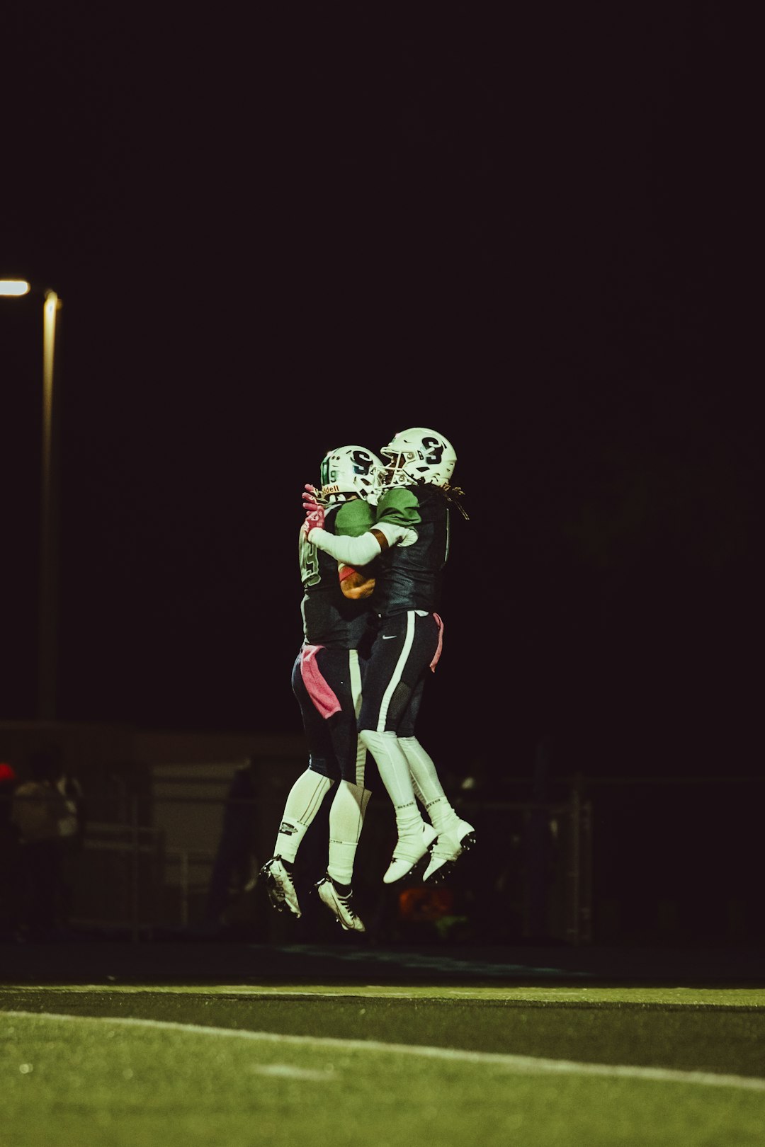 two football players hugging each other on a field defensive tackle sack, nfl turnover, football interception celebration