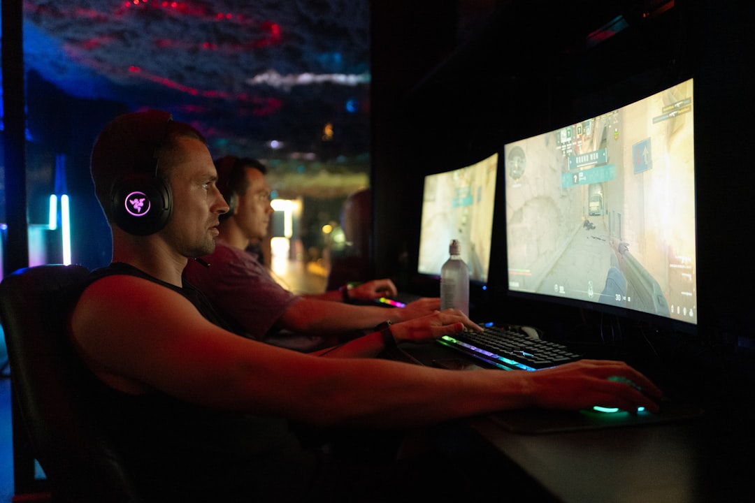 Two men playing video games on computers esports arena, gaming tournament stage, large crowd, multiplayer battle game screen