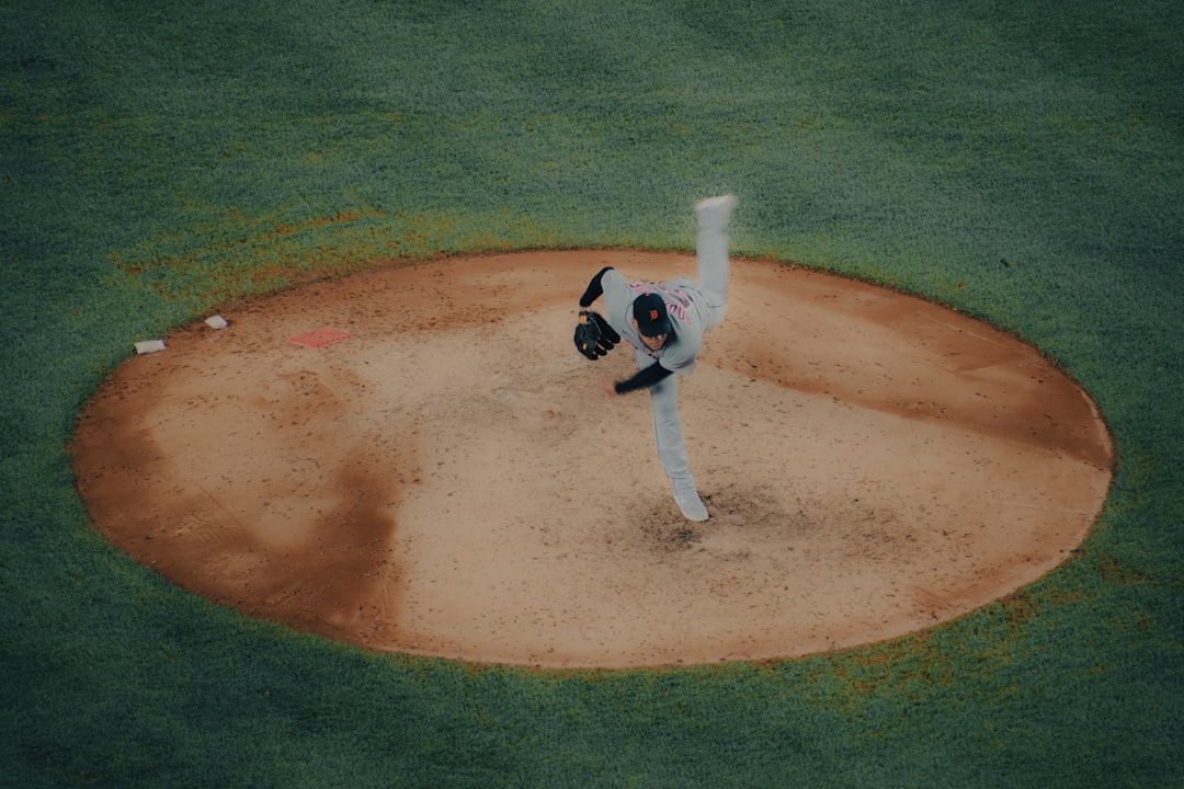A baseball player pitching a ball on top of a field close up baseball pitcher release point, high arm angle, fastball motion