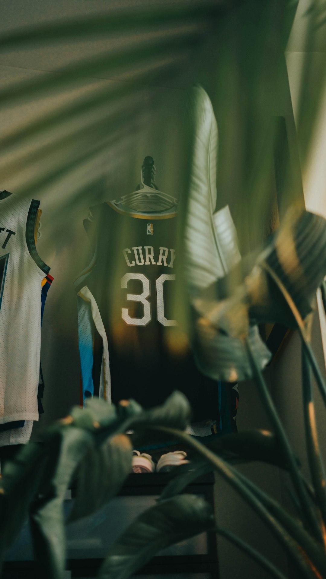 a basketball jersey on a table next to a plant stephen curry finals mvp trophy 2022, warriors vs celtics, championship celebration confetti