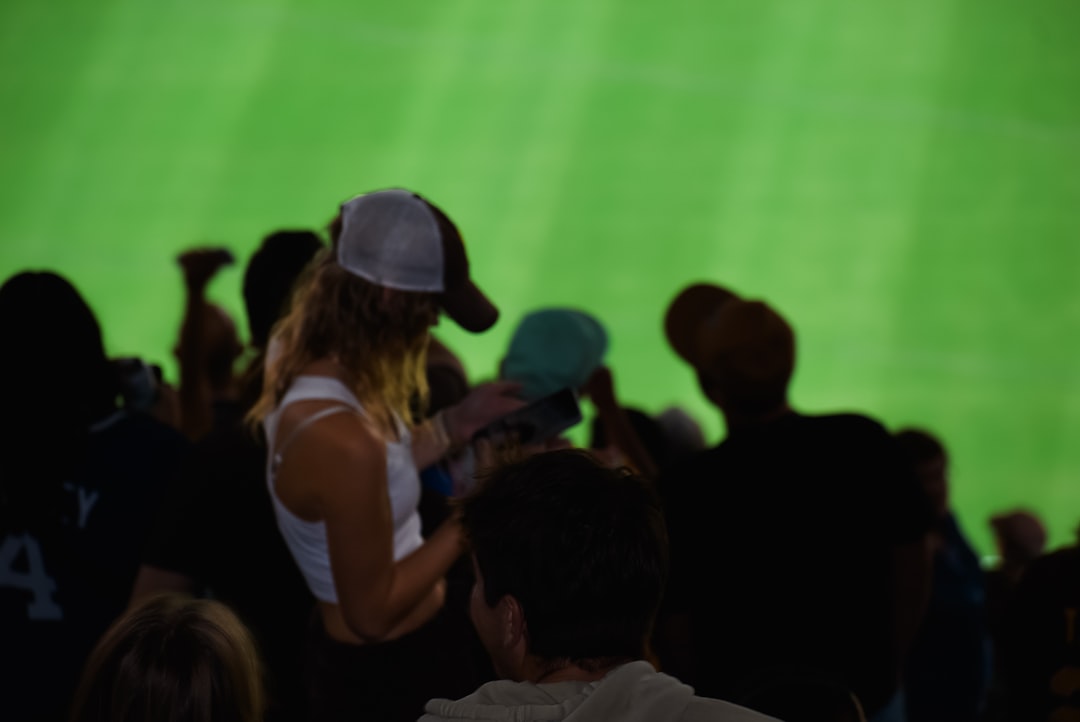 A crowd of people standing around a tennis court football third down play, nfl coaches sideline discussion, packed stadium crowd cheering