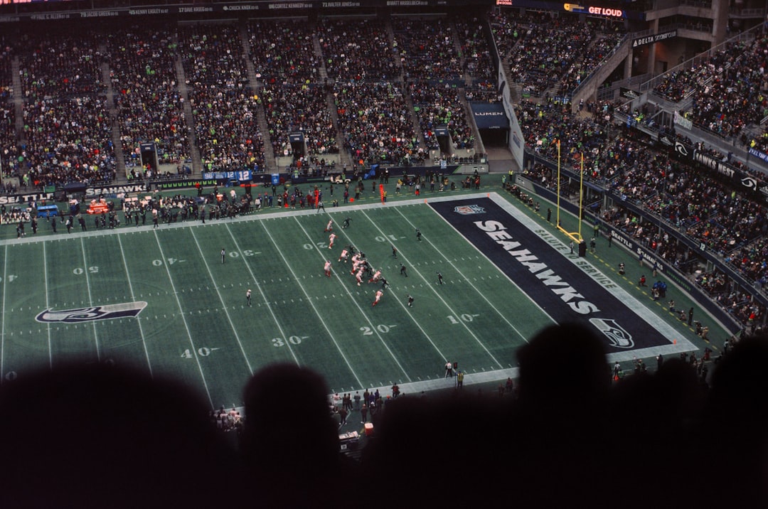 a football stadium filled with lots of people football stadium night game crowd, nfl field action, scoreboard lights