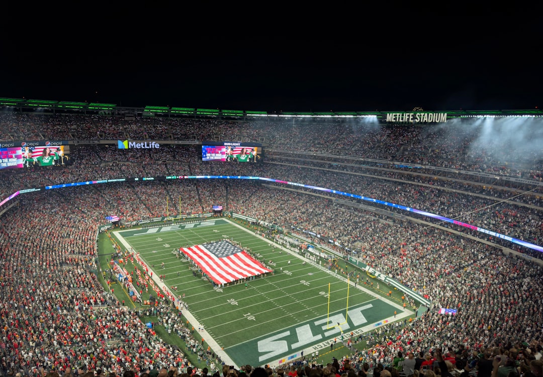 a football stadium filled with lots of people football stadium night game crowd, nfl field action, scoreboard lights