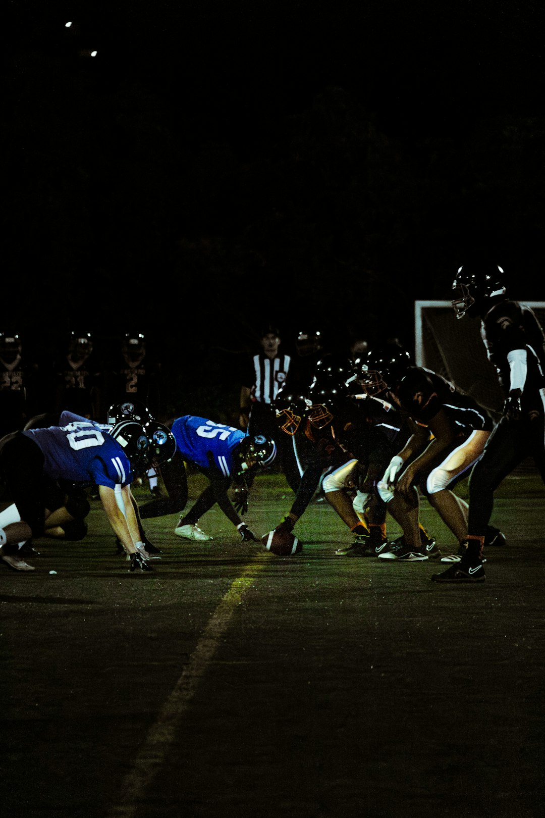 a group of football players on a field nfl defensive tackle sack, football interception catch, intense stadium lights night game