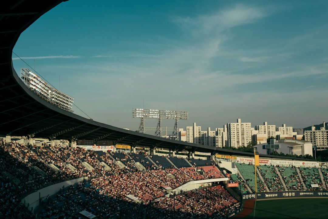 a stadium filled with lots of people watching a game baseball stadium aerial view, sunny day game, crowd in stands