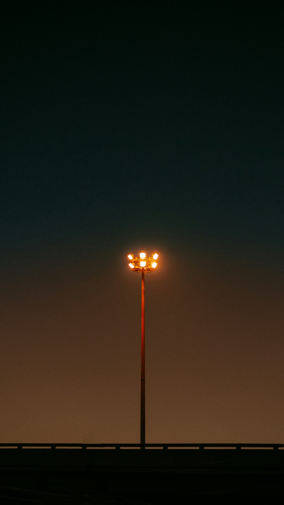 a street light sitting on the side of a road football field goal attempt, stadium lights night game, football sailing wide