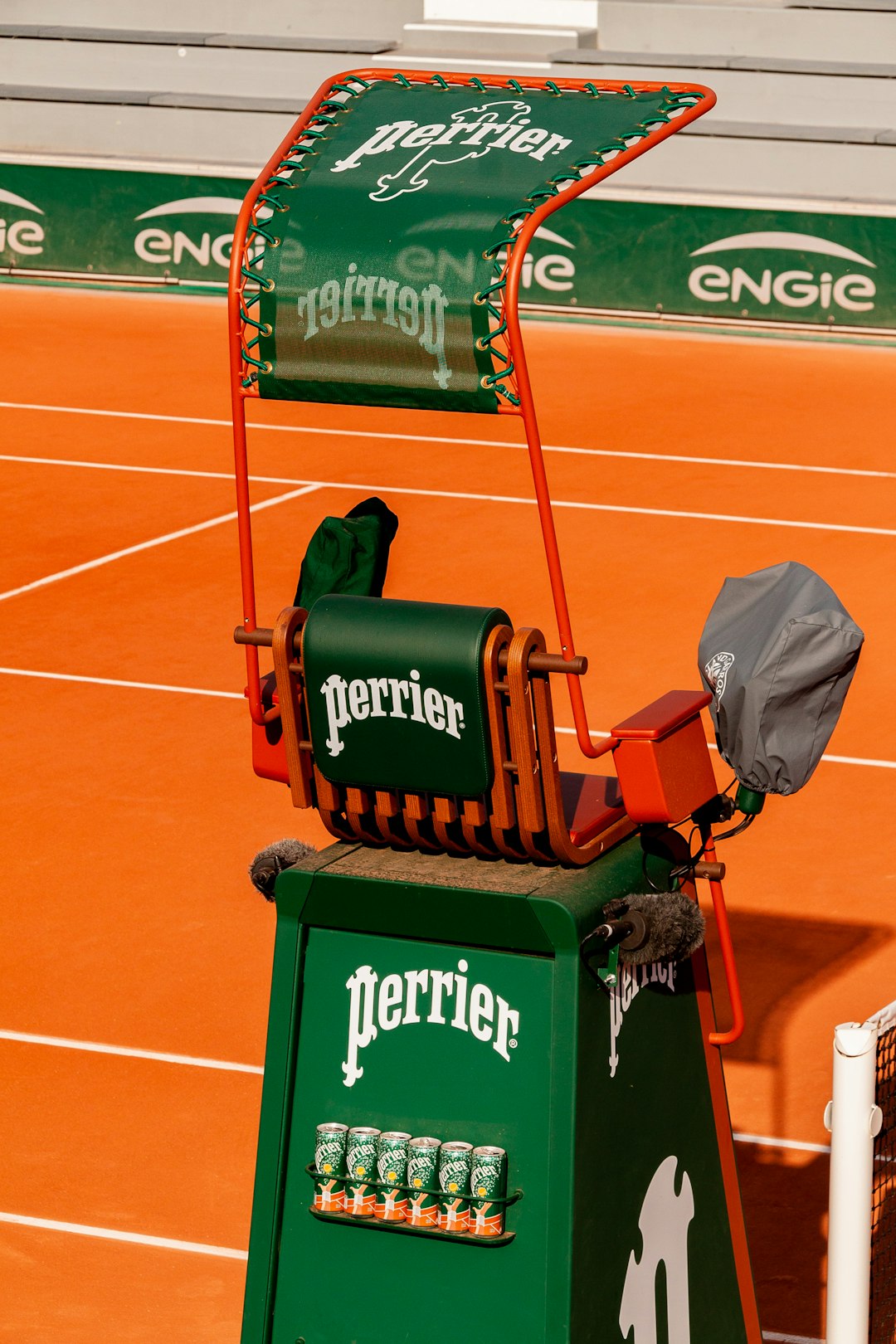 A tennis umpire chair is on the court. tennis semifinal match, clay court rally, passionate crowd paris